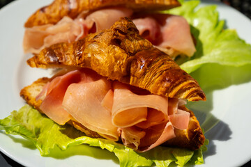 Croissants sandwiches with prosciutto (jamon, cured ham, prosciutto crudo) and lettuce. Delicious...