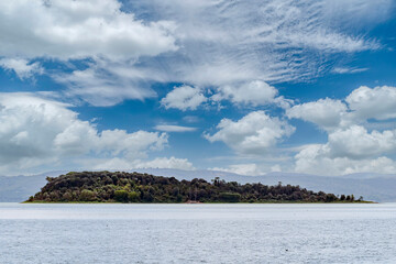 Isola Minore island in Lake Trasimeno, view from Tuoro, Perugia Italy, under a beautiful sky