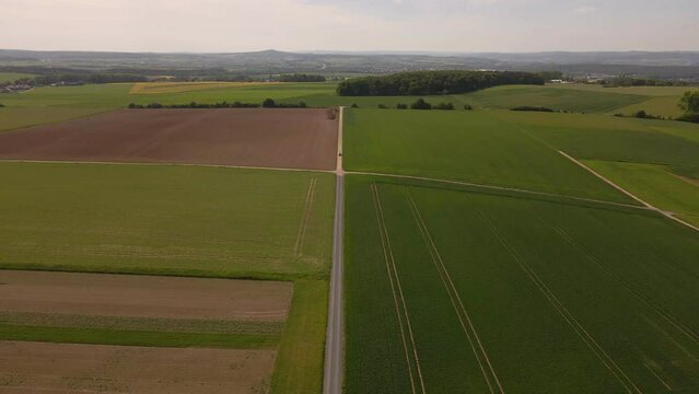 Aerial Shot Of A Remote Quiet Countryside Road With A Singular Car Travelling Beside Lucious Fields In Germany Near The Grueninger Warte.
