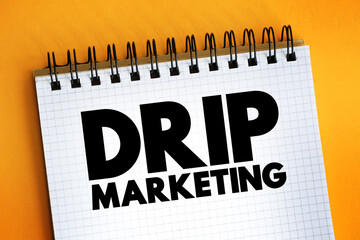 Drip marketing - communication strategy that sends a pre-written set of messages to customers or prospects over time, text concept on notepad