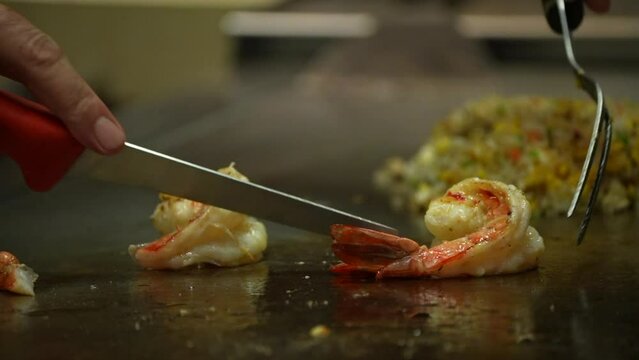 Teppanyaki Restaurants fry prawns and cutting wassting part