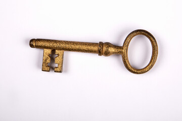 Gilded old fashioned door key on white background