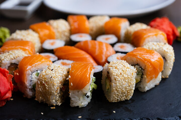 Sushi set close-up on black board. Traditional Japanese seafood