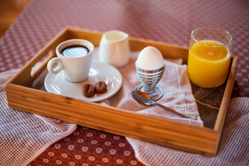 Boiled egg for breakfast close up shoot. Breakfast with boiled egg, orange juice and coffee. Sunny morning