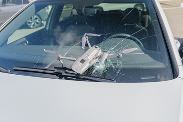 Fototapeta na wymiar Accident with drone on the road. Windshield and drone destroyed. Liability insurance compulsory for drone pilots.