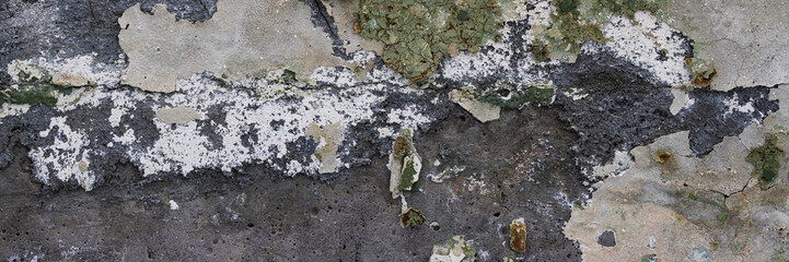 Peeling paint on the wall. Panorama of a concrete wall with old cracked flaking paint. Weathered rough painted surface with patterns of cracks and peeling. Wide panoramic grunge texture for background