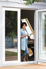 middle aged woman  wiht dog and  a cup of tea relaxed in the garden   near the house in summer. concept without stress. mental health. Slow life. Enjoying the little things. 