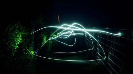 Lightpainting auf einem Weg mit einer Hecke am Rand