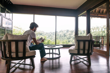 Man reading book in hotel room