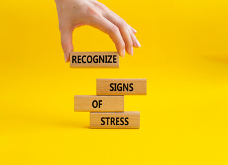 Recognize Signs of Stress symbol. Concept words Recognize Signs of Stress on wooden blocks. Beautiful yellow background. Businessman hand. Medicine and Business concept. Copy space