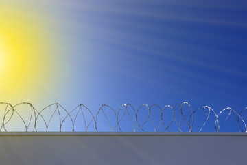 concertina fence installed on a wall and a blue sky background