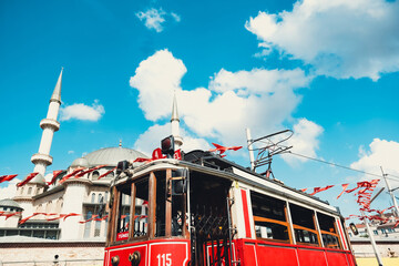 Taksim historical tram with Taksim Mosque in background, beautiful cityscape in Istanbul, blue...