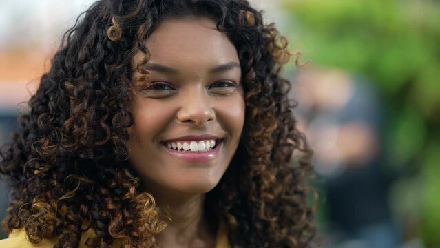 One happy black girl with curly smiling. Portrait face closeup of a Brazilian hispanic African American young woman