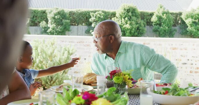 Video of african american family spending time together and having dinner outside