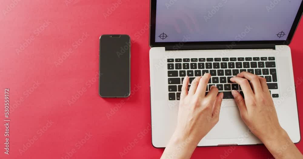 Wall mural hands using laptop with smartphone on red desk with copy space