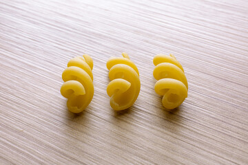 small compositions of durum wheat pasta on wooden background