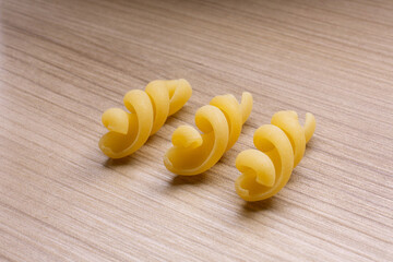 small compositions of durum wheat pasta on wooden background