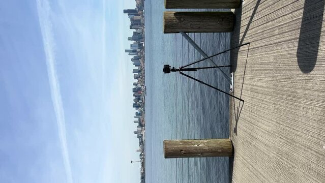 Vertical Shot Of A Camera Mounted On A Tripod On The Pier At Luna Park With View Of Seattle Skyline Across Elliott Bay.