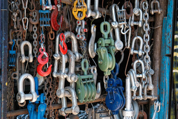 Colorful rusty and new marine types of equipment, hanging rusty chains, red hook, maritime and ship equipment, sea and marine market idea