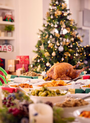 Table At Home Set For Christmas Lunch With Roast Turkey And Vegetables With Decorations