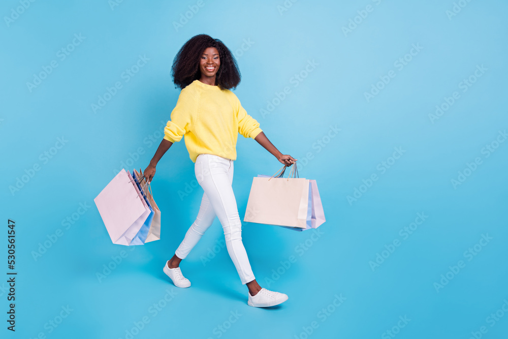 Poster full size photo of overjoyed girl arms hold packages have good mood empty space isolated on blue col