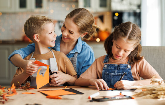 Young family mother  and children preparing decorations for Halloween