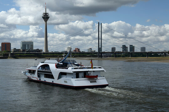 journey by a luxury yacht floating down the river on a beautiful summer day against the backdrop of the tv tower in Dusseldorf 