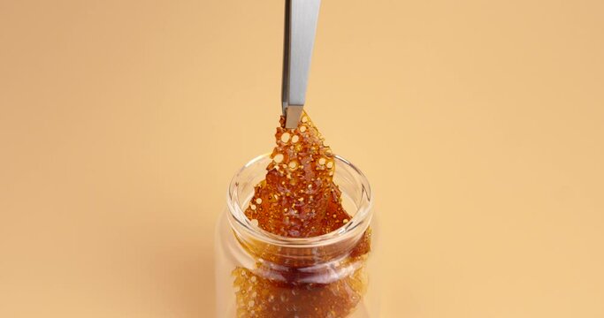 detail of resin wax of marijuana amber concentrate on dabbing tool. High quality 4k footage