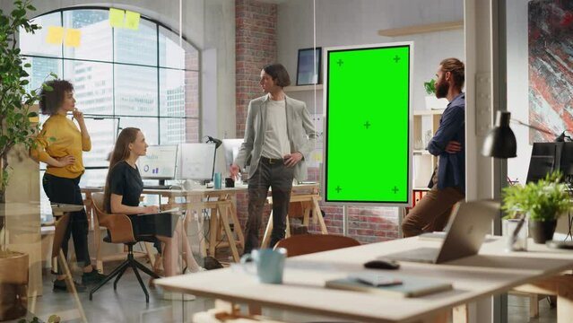 Junior Marketing Specialist Making a Team Presentation in Creative Office Meeting Room. Project Manager Showing a Fresh Product Timeline on Green Screen Mock Up Chroma Key Display.