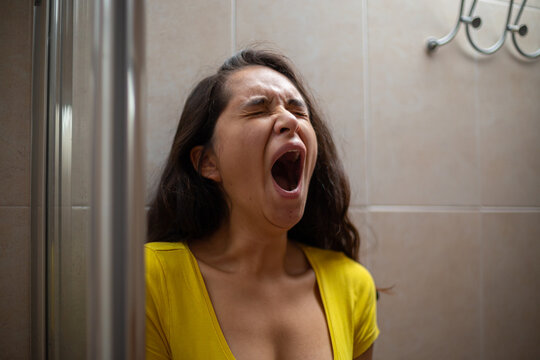 Tired Woman Yawning In The Bathroom 