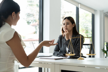 Asian female lawyer discussing negotiation legal case with client meeting with document contact in...