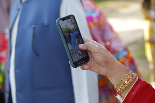 A young woman takes photos on the phone at the wedding.