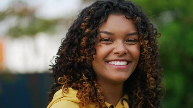 South American black girl standing outdoors looking at camera. Portrait face closeup of Brazilian happy person with joyful expression