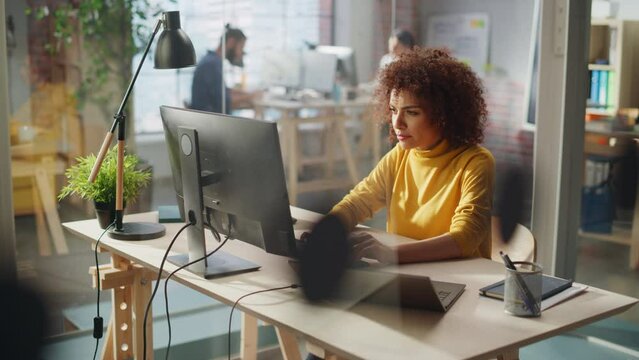 Middle Eastern Female Sitting in Creative Agency, Working on Implementing Modern Business Strategy for a Client. Successful Specialist Writing Corporate Project Plans on Laptop Computer.