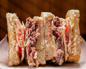 Minced beef steak, bacon, lettuce and tomato (BLT) sandwich.
