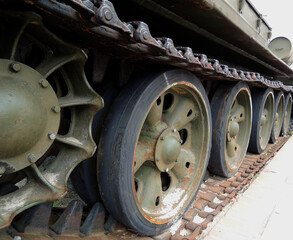Fototapeta na wymiar Wheels and suspension of rare tracked war machine with dirt and rust on a tracks