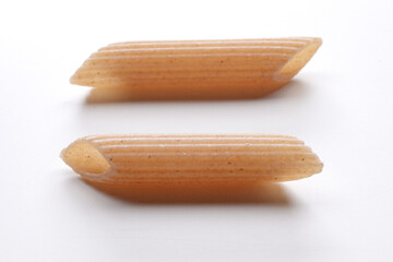 small composition of whole durum wheat pasta on a white background