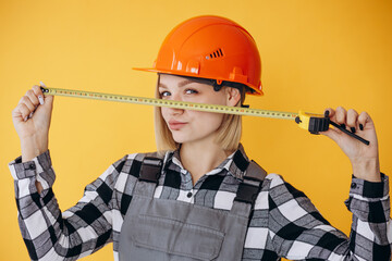 Woman builder wearing orange hard hat and overalls using roulette
