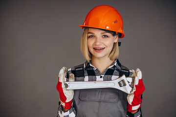 Woman builder in hard hat holding french key tool