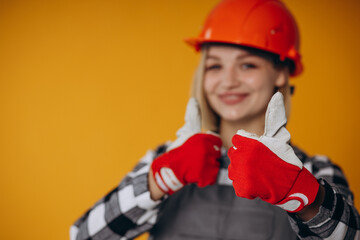 Woman builder in orange hard hat isolated on orange background