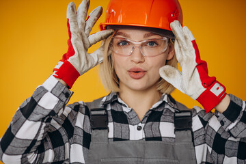 Woman builder in orange hard hat isolated on orange background