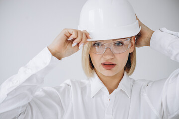 Business woman engineer wearing white har hat and holding plan