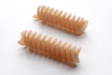 small composition of whole durum wheat pasta on a white background