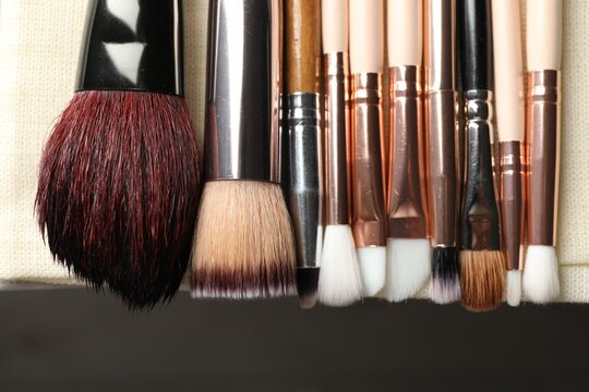 Set of different makeup brushes drying after cleaning on table, flat lay