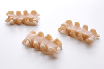 small composition of whole durum wheat pasta on a white background