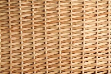 Handmade wicker basket made of natural material as background, closeup view