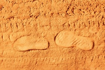 Footprints from shoes on dry, dusty ground