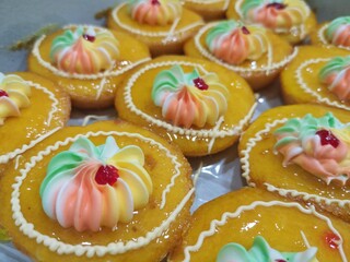 Cakes, bakeries, skins made with marmalade. There is a cream of iridescent color, made in the shape of a spiral.