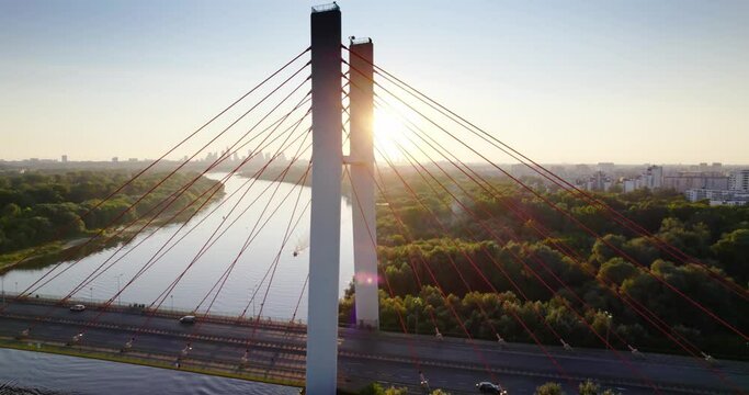 Aerial view of Wisla Vistula River, Siekierkowski bridge and Warsaw city center at midnight sun. Beautiful sun flare.
