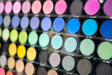 Colorful eyeshadow pallet for make up in cosmetic store - close up view. Makeup, beauty, fashion and glamour concept